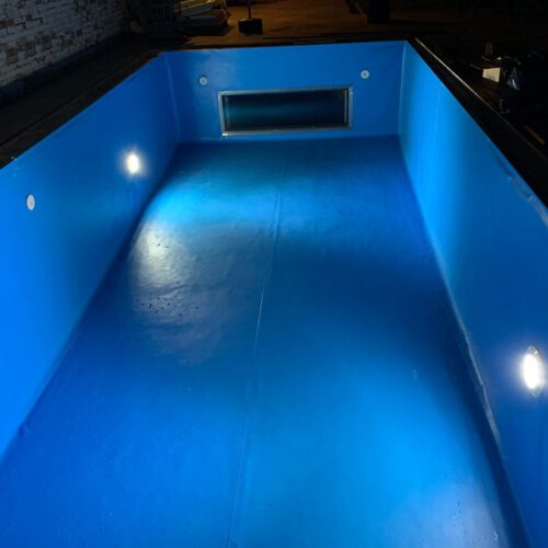 Piscina 7x3m en lámina azul con ventana de cristal al salón en Castrillo del Val